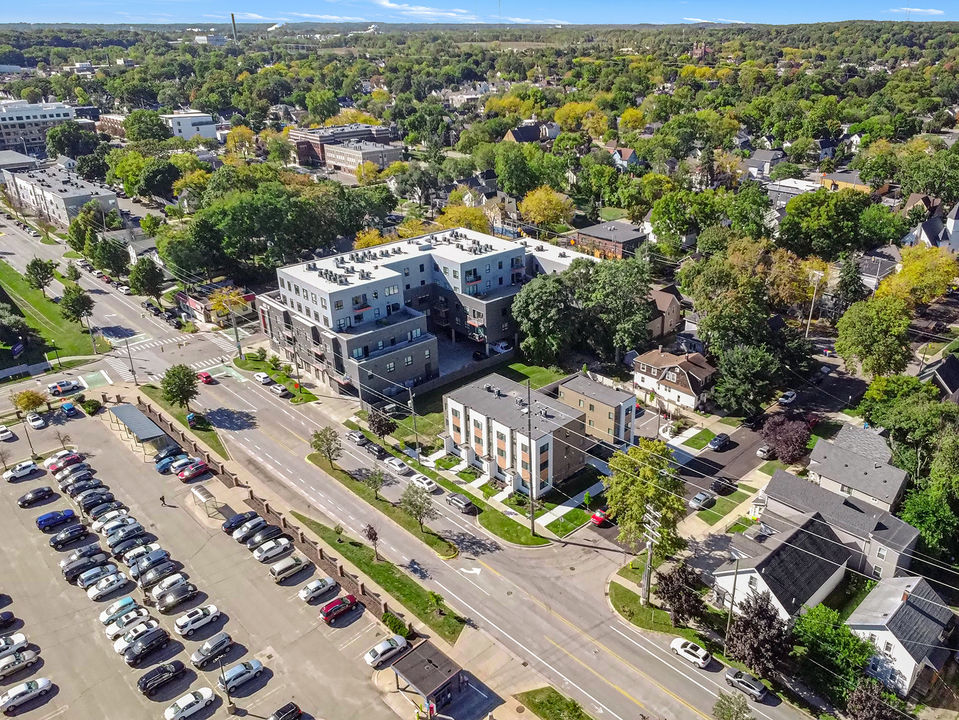 Aerial view of modern apartment complex and neighborhood with green trees