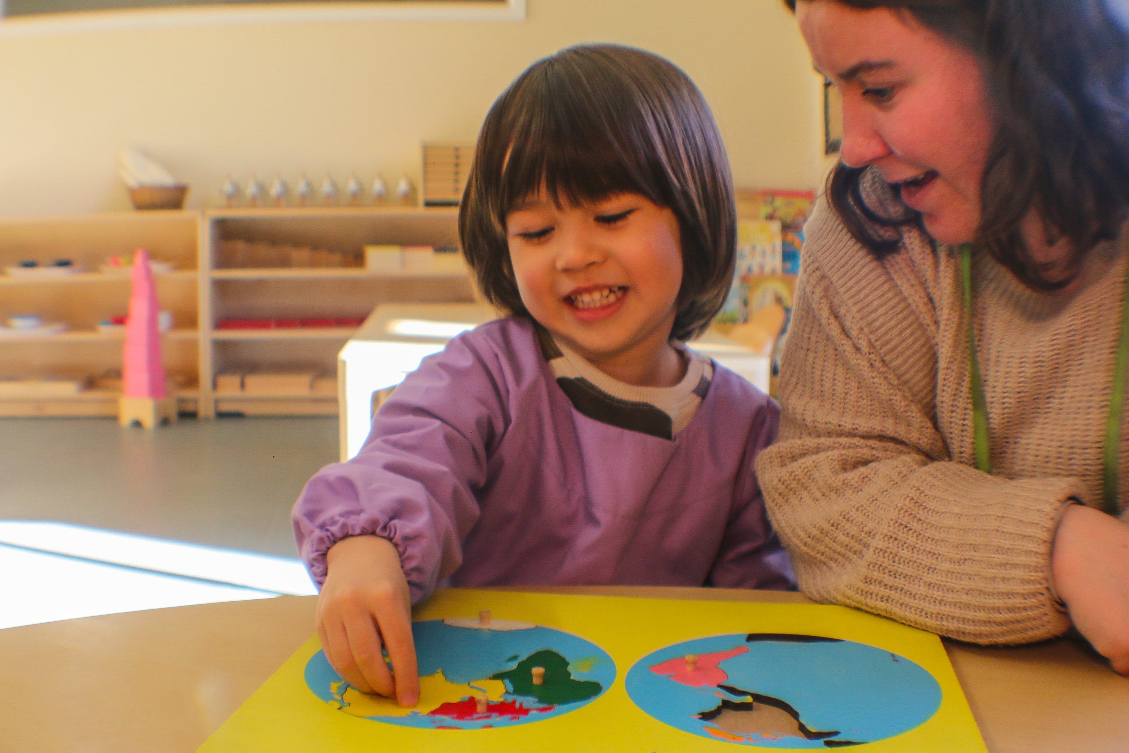 Smiling child playing with a teacher