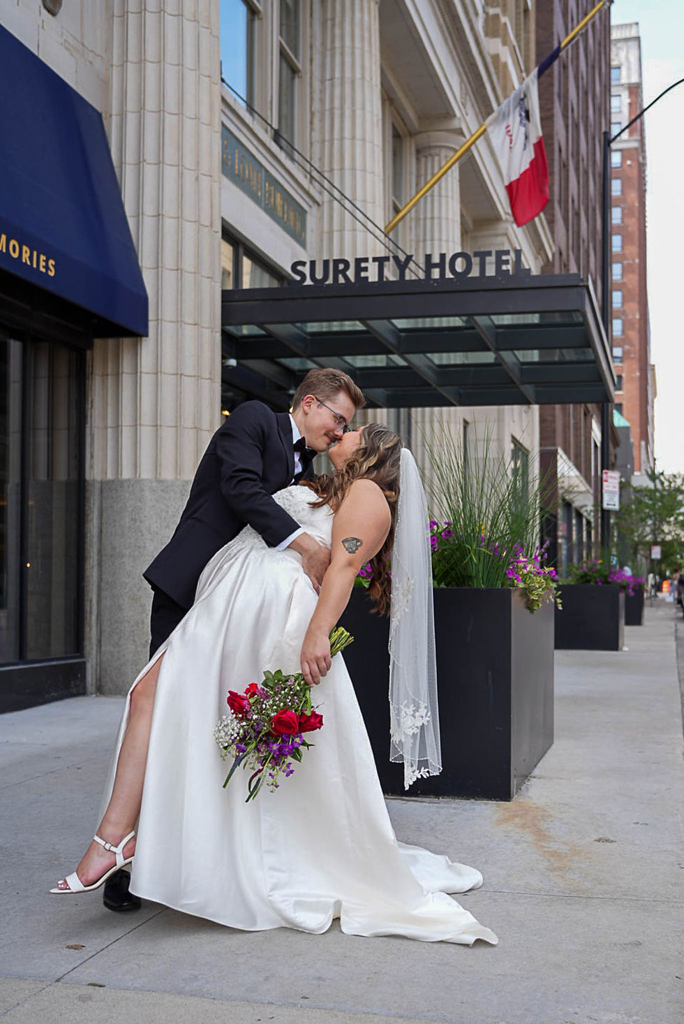 Wedding couple poses for wedding photographer at Surety Hotel in Des Moines Iowa