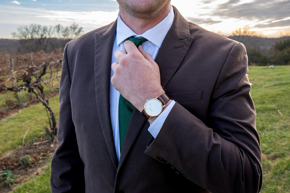groom posing to show watch and tie