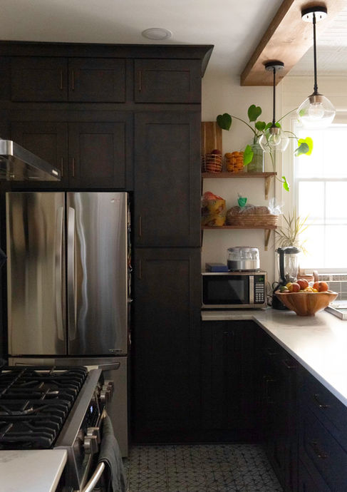Kitchen with breakfast bar peninsula, with dark wood cabinets and white countertop