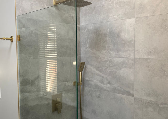 Gray Porcelain tile with gold trim and gold shower fixture