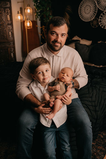 Arlington Newborn family photos in a dark boho style bedroom.