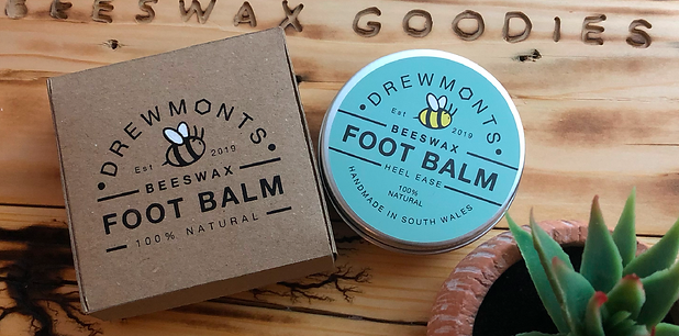 Drewmonts Heel Ease Foot Balm in a recyclable aluminium tin, displayed next to its handmade recycled Kraft box. A 100% natural beeswax balm designed to deeply nourish and soften dry, tired feet.