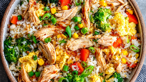 A bowl of boiled rice, mixed vegetables and steamed chicken breasts
