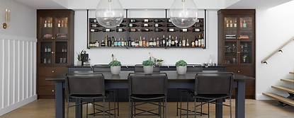 Modern entertainment and bar area with dark wood built-in cabinetry, glass display cabinets, and a wall-mounted wine and liquor storage system. Features include oversized glass pendant lighting, a large communal table with leather bar stools, brass accents, floating wood stairs, and a clean contemporary design with warm natural finishes.