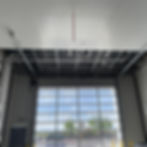 Construction progress of a car wash facility featuring newly installed PVC panels and open framework against a backdrop of the clear outdoor view.