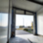 Construction progress of a car wash facility featuring newly installed PVC panels and open framework against a backdrop of the clear outdoor view.
