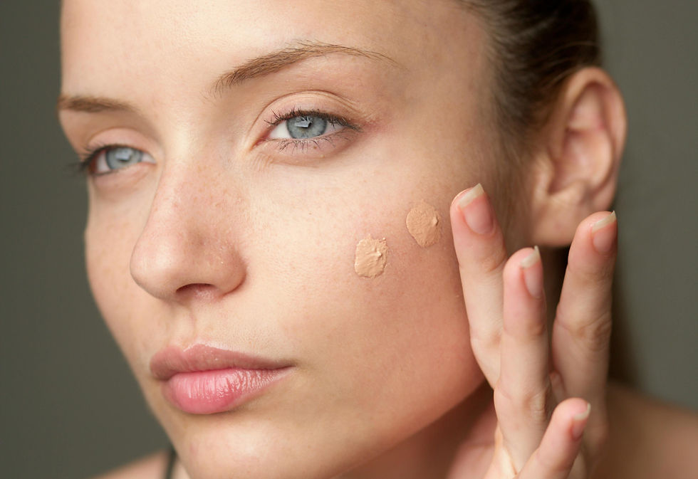 young woman applying makeup foundation