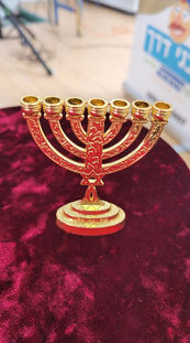 חנוכיה מוזהבת מונחת על לבד אדום