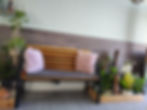 Wooden bench with pink cushions in an aromatherapy massage UK clinic waiting area