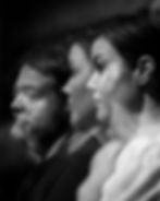 Black and white image of two people in profile, with blurred reflections. The mood is thoughtful and introspective.