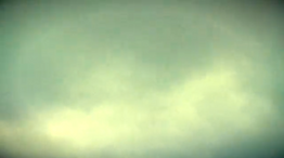 L'image montre des nuages flous verdrâtre. La vidéo renvoit au film "thursday afternoon" de Brian Eno
