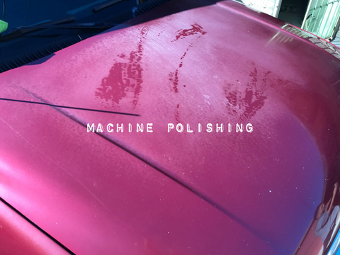 Machine polishing on a faded red car hood.