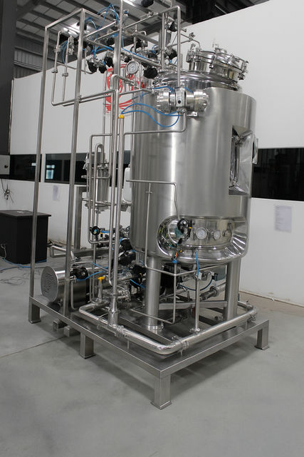 High-resolution stainless steel industrial mixing and homogenizing machine with control panel and funnel, used in pharmaceutical, biopharma, cosmetic, and food processing applications for blending, emulsification, and formulation.