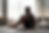 Silhouette of a person sitting on steps, head resting on hand. The scene is monochrome, creating a somber, contemplative mood.