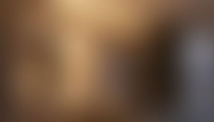 Frau mit Buch in der Hand auf einem Sofa in einem angenehm beleuchteten Wohnzimmer