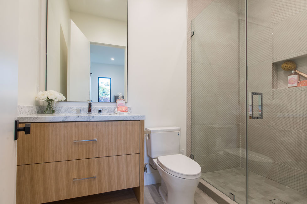 Modern bathroom in Los Angeles featuring a glass walk-in shower, floating vanity, and contemporary tile finishes.