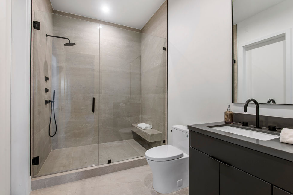 Modern luxury bathroom in Los Angeles new construction home featuring walk-in glass shower, matte black rainfall fixtures, and minimalist design.