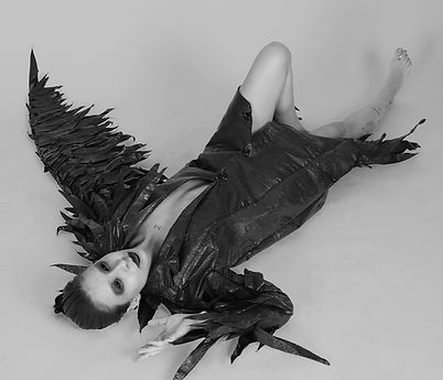 Foto do editorial da peça "noxavi".
Modelo deitada no chão, braços abertos, o braço direito levemente flexionado em direção a cabeça e a perna esquerda recolhida