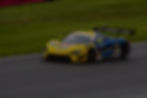 Yellow and blue race car with number 59 on track. Upgrade Motorsport.