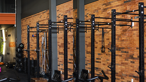 Academia em dia claro com materiais de musculação e ao fundo uma parede com o revestimento da Cerâmica Alves Candiba