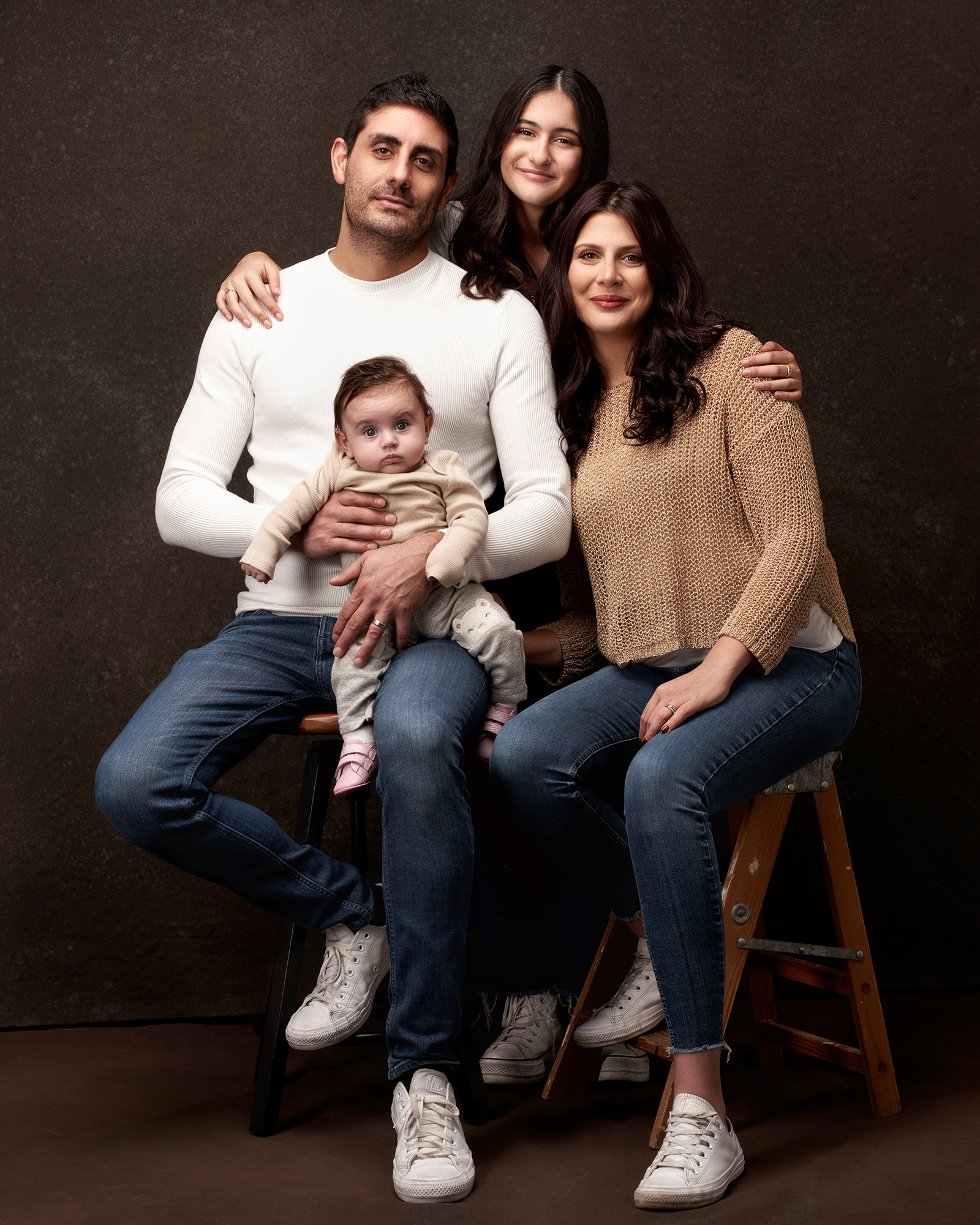 Parents avec leur bébé lors d’une séance photo de famille en studio.