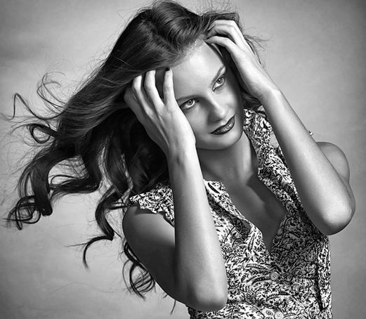 Portrait artistique en noir et blanc d’une femme aux cheveux bouclés, réalisé en studio à Longueuil.