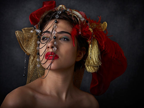 Portrait artistique d’une femme avec coiffe rouge et noire, réalisé dans un studio de design à Montréal.