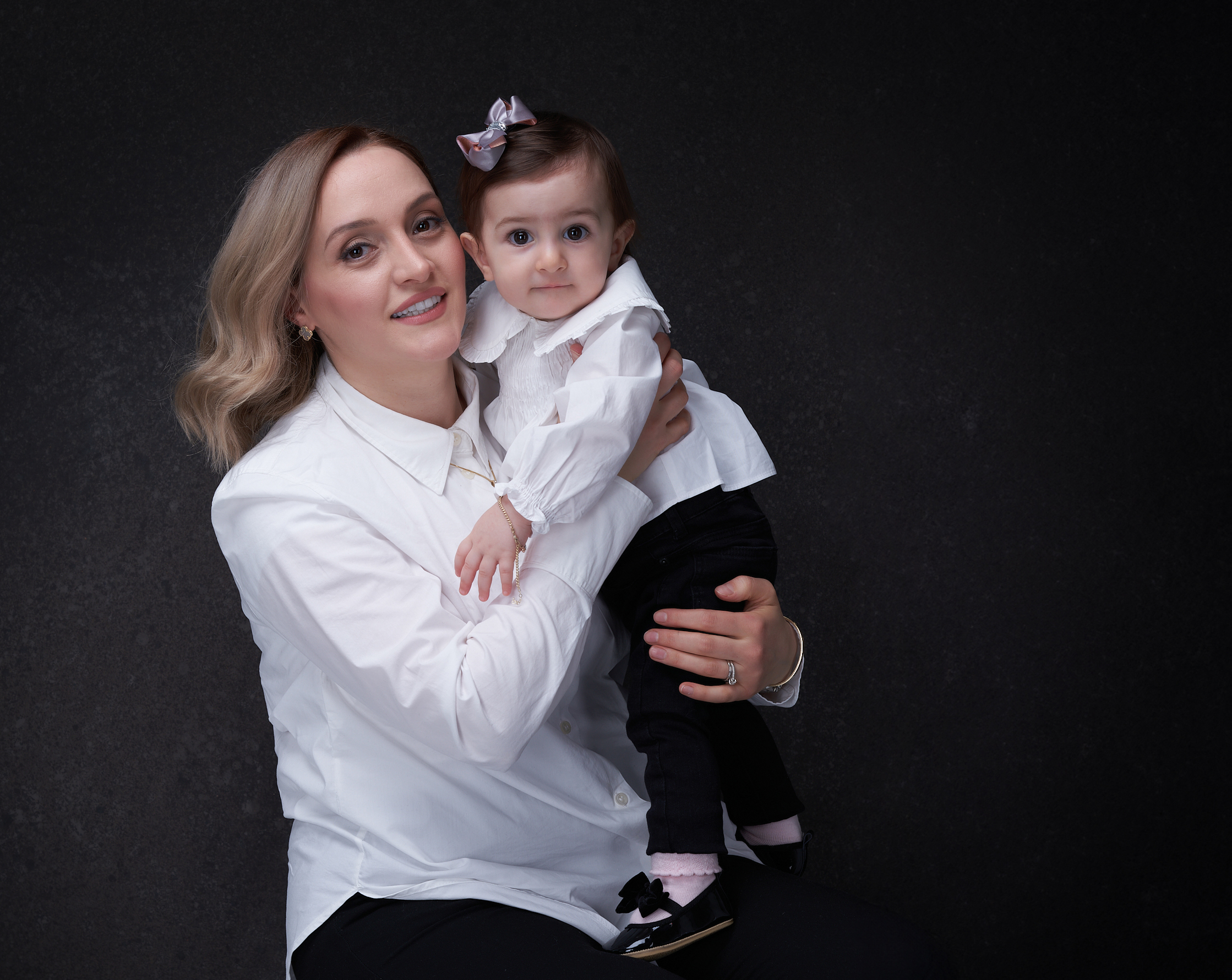 Mère tenant son bébé dans ses bras pour un portrait familial en studio à Longueuil.