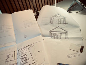 This photograph shows sketches and drawings for an extension of a home.