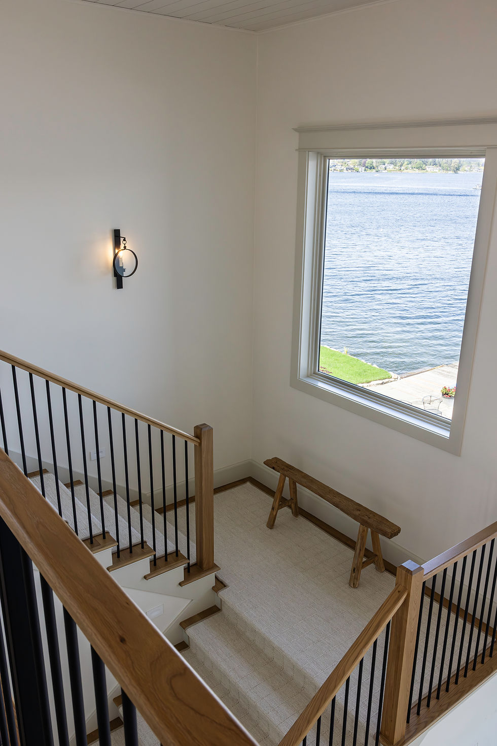 Stair landing with a wood handrail and views of the lake and mountains