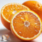 A fresh orange with water droplets on it, cut in half illustrating several senses