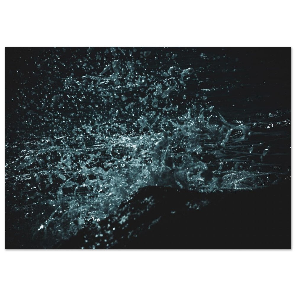 Close-up abstract image of splashing water in motion, with scattered droplets and bright highlights against a shadowed backgr