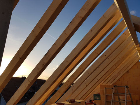 Dachkonstruktion aus Holz bei Sonnenuntergang in Winkel