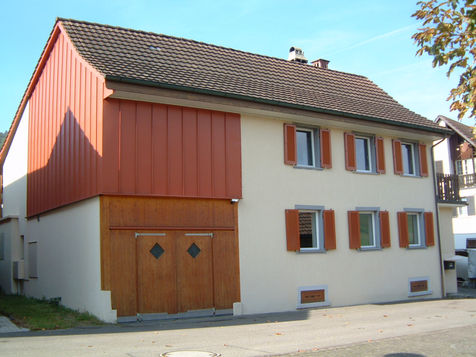 frisch renoviertes Einfamilienhaus mit Scheune und einer roten Holzfassade