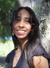 A woman posed outside for a photo in a black top