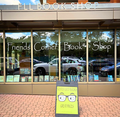 The outside of a shop with large glass windows and a lime green a frame sign