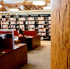 Computers at a desk and bookshelves in the background