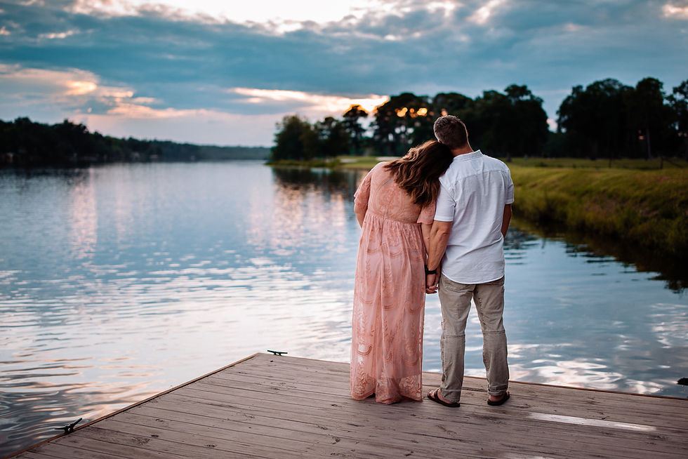 Couple stands on a wooden dock by a lake at sunset. Photographed by Warner robins photographer.