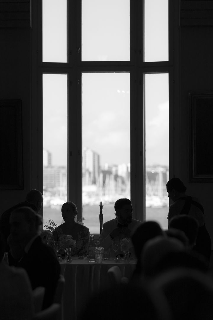 Siluettikuva hääparista ikkunaa vasten