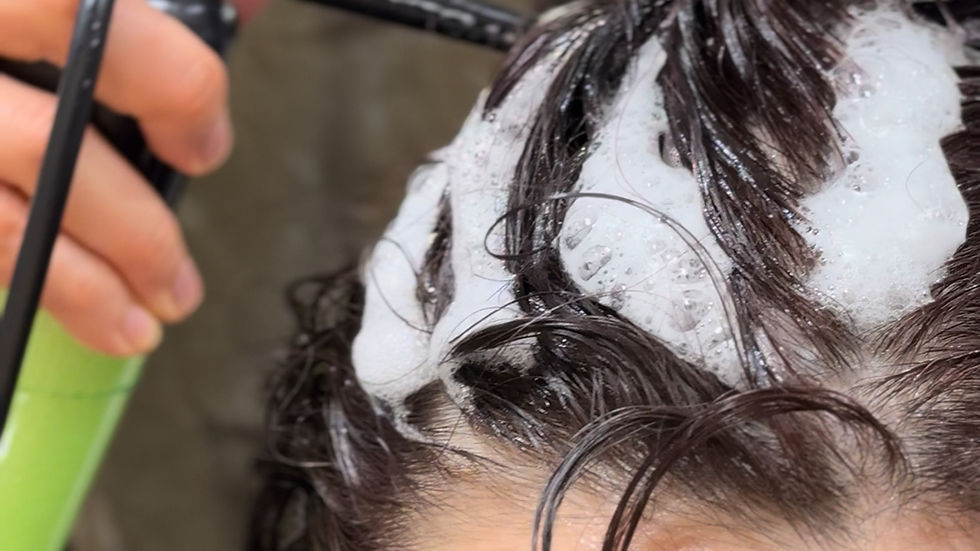 Close-up view of a scalp treatment device applying serum on hair roots