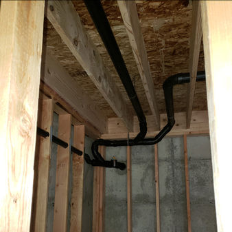 Plumbing pipes routed through 2x4 joists in a basement by Shelco Plumbing of Snohomish County
