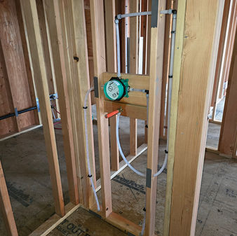 Plumbing connection installed in the framing for a new home's bathroom shower