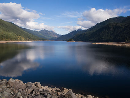 Tolt River Watershed lake with forested hills and a blue sky with clouds