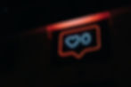 A neon sign in the shape of a social media "Like" button