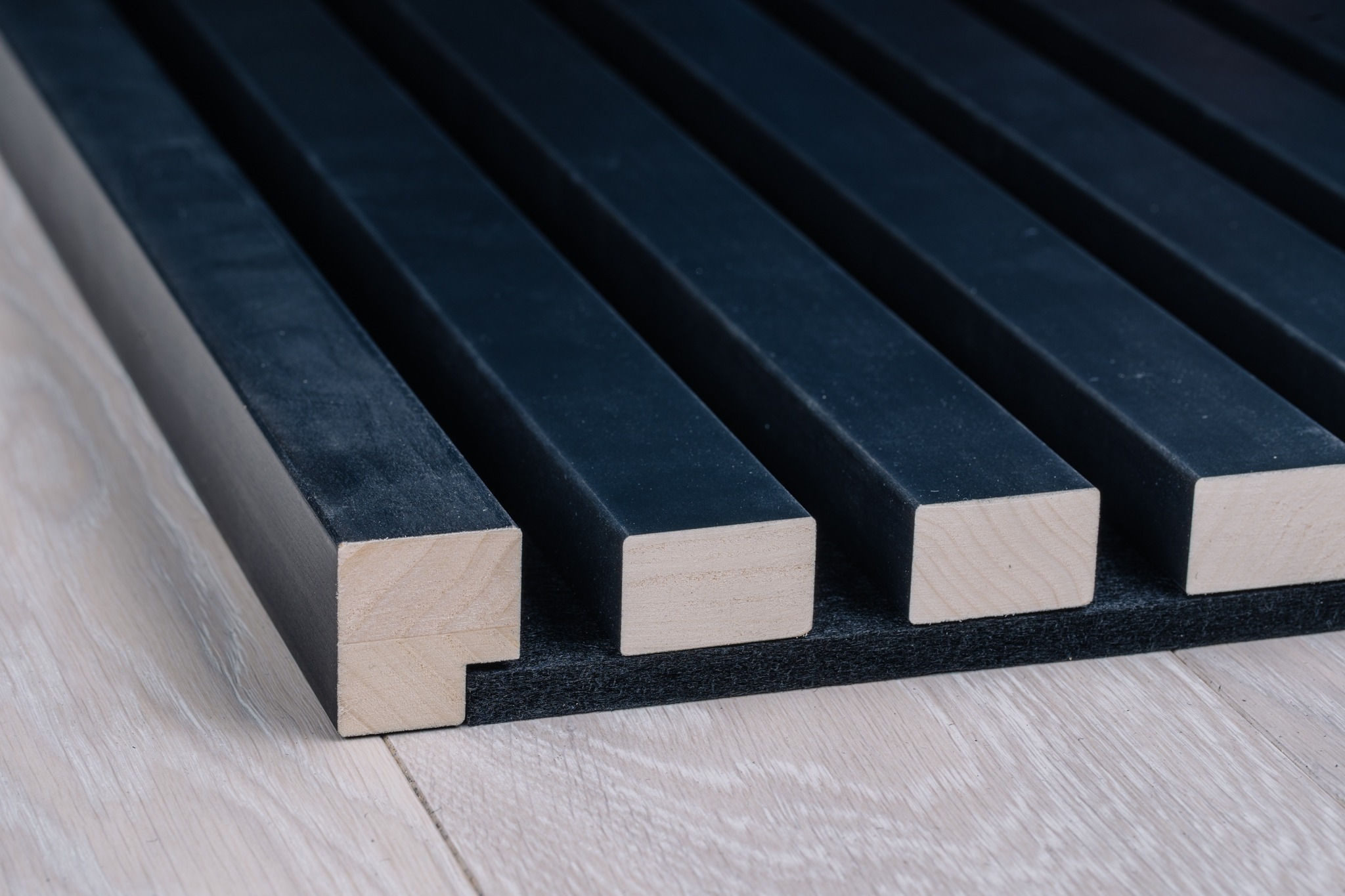 Anthracite end moulding installed with acoustic wood panels