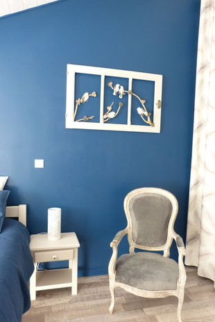 Vue du fauteuil et d'un détail de décoration de la chambre Mésange Bleue au Jardin du Dolaizon au Puy en Velay.