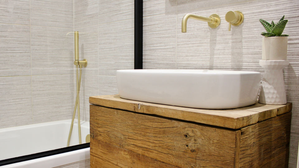 a standalone sink sits on top of a wooden vanity unit