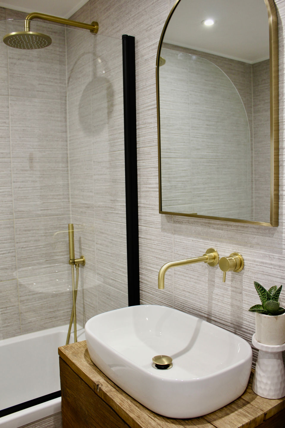 a sink with mirror above and shower alongside